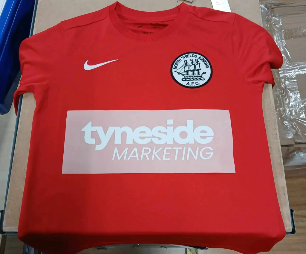 a red NSJAFC strip with Tyneside Marketing test logo printed on it